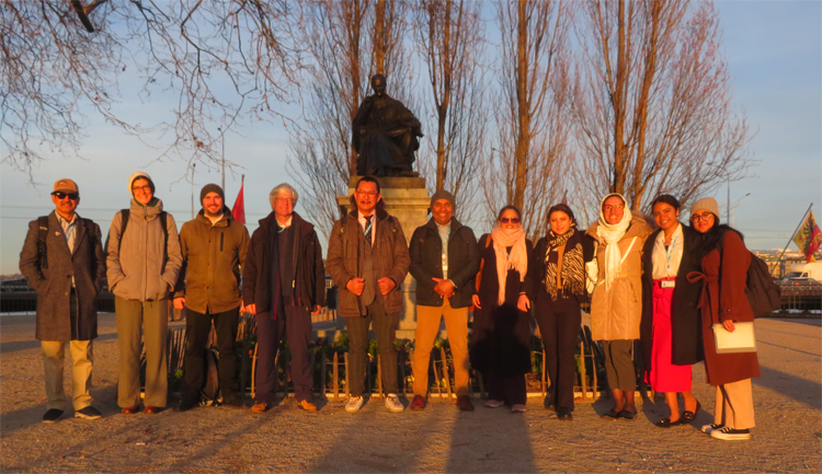 Participants under Rousseau's statue on the DESC Walk in Geneva, 16 March 2023